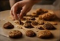 Hands arranging cookies on a tray
