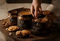 Hands filling jars with cookies